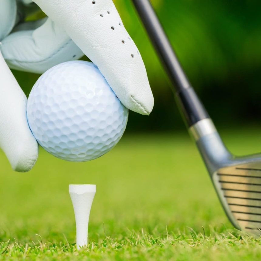 Close up view of golf ball on tee on golf course